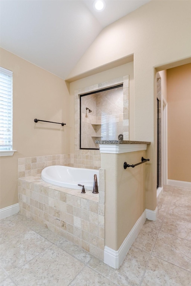 bathroom featuring independent shower and bath, vaulted ceiling, and tile patterned floors