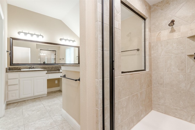 bathroom featuring vanity, tile patterned floors, lofted ceiling, and a tile shower