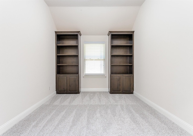 unfurnished room with lofted ceiling and light carpet