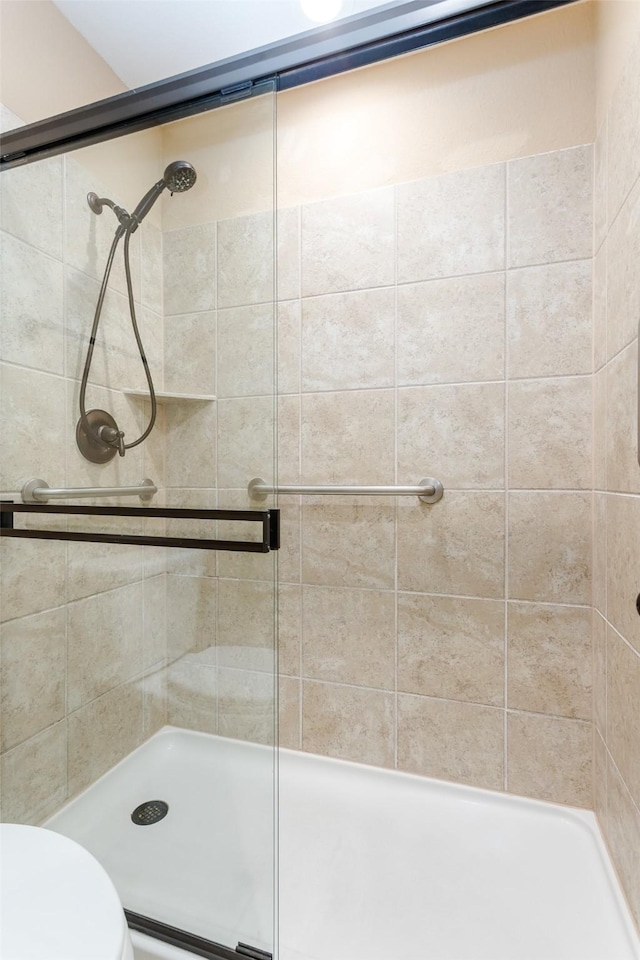 bathroom featuring an enclosed shower and toilet