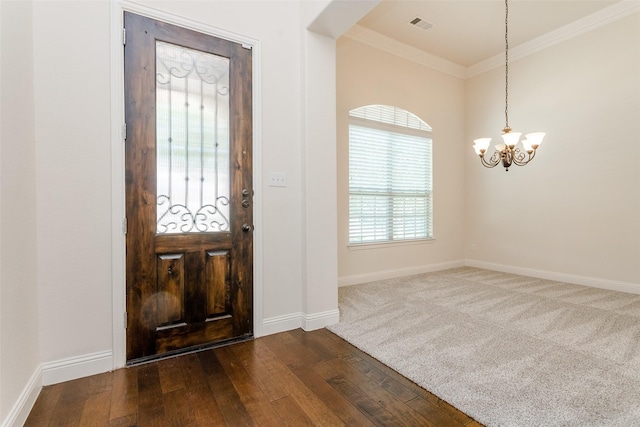 foyer featuring dark hardwood / wood-style flooring, a notable chandelier, and ornamental molding