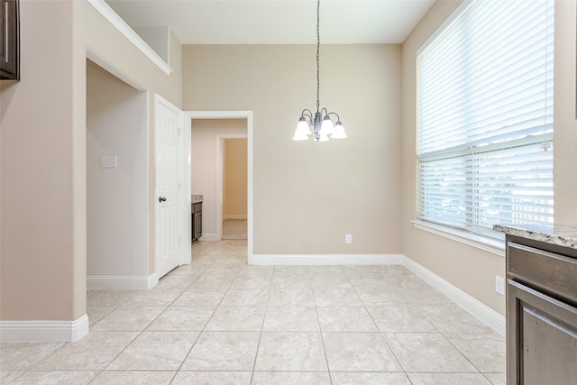 unfurnished dining area featuring an inviting chandelier and light tile patterned floors