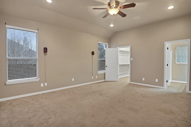 interior space with ceiling fan, light colored carpet, and vaulted ceiling