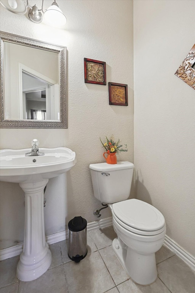 bathroom featuring sink, tile patterned floors, and toilet