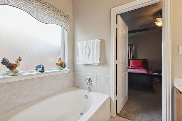 bathroom featuring ceiling fan, vanity, and a washtub