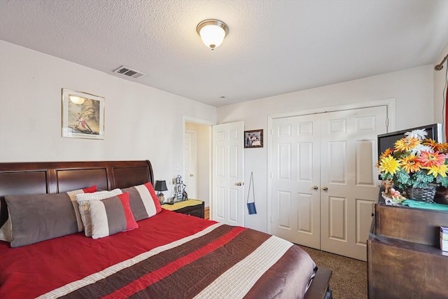 bedroom with a closet, a textured ceiling, and carpet flooring