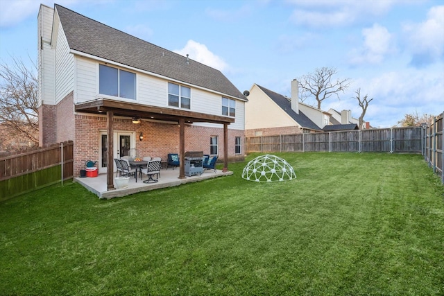 back of property featuring a lawn and a patio area