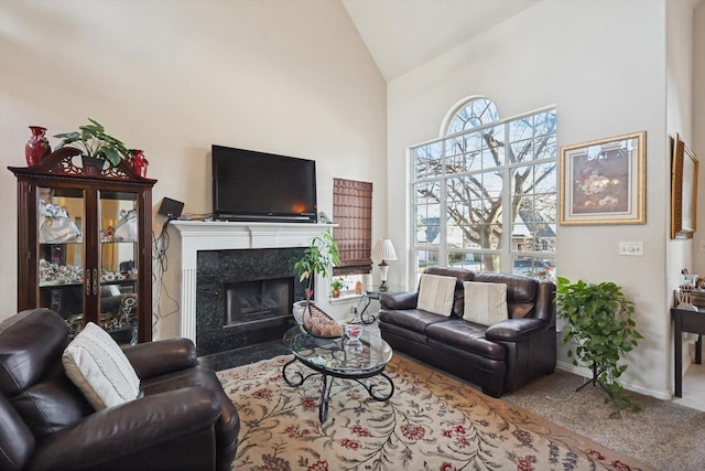 living room featuring carpet floors, a fireplace, and high vaulted ceiling