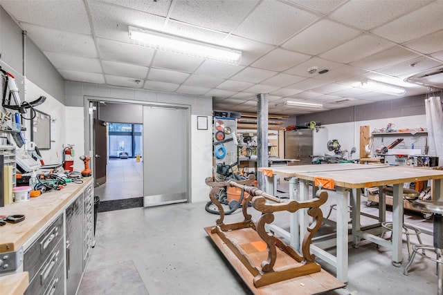 interior space with a drop ceiling and a workshop area