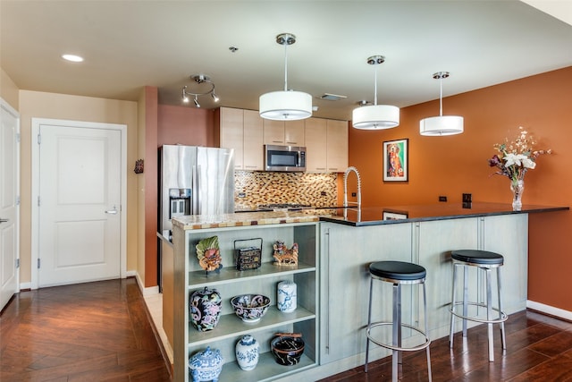 kitchen featuring sink, appliances with stainless steel finishes, dark hardwood / wood-style floors, kitchen peninsula, and backsplash