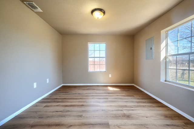 unfurnished room with light hardwood / wood-style flooring and electric panel