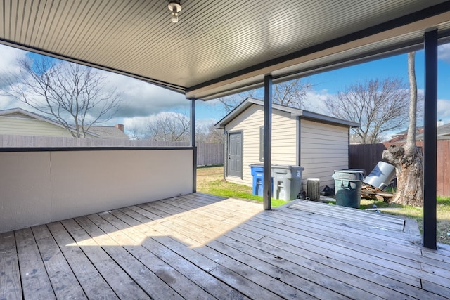 wooden deck with area for grilling and an outbuilding