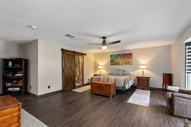 bedroom with ceiling fan, a barn door, and dark hardwood / wood-style flooring