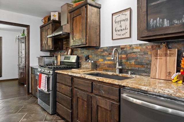 kitchen with wall chimney range hood, sink, appliances with stainless steel finishes, backsplash, and dark brown cabinets