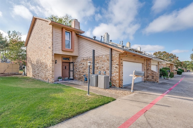 view of front of house with a garage, a front yard, and central AC unit