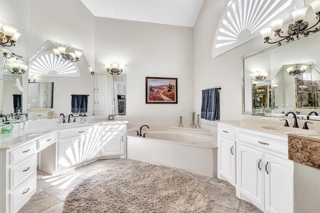 bathroom featuring vanity, high vaulted ceiling, a washtub, and an inviting chandelier