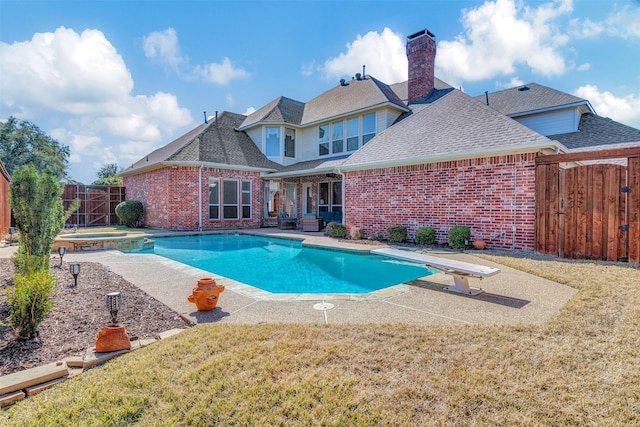 view of pool with an in ground hot tub, a diving board, a patio area, and a lawn