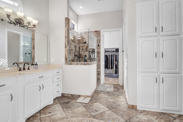 bathroom featuring vanity, tiled shower, and a chandelier