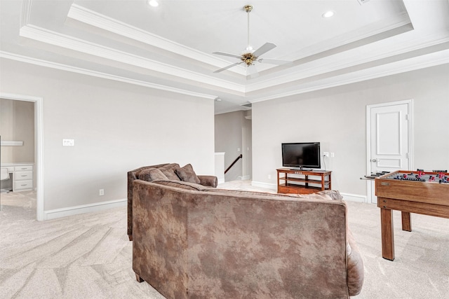 carpeted living room featuring ornamental molding, ceiling fan, and a tray ceiling