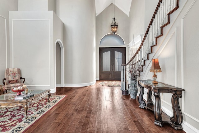 entryway with an inviting chandelier, plenty of natural light, hardwood / wood-style floors, and a high ceiling