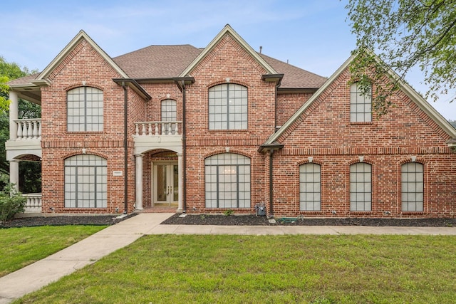 view of front of home with a front lawn and a balcony