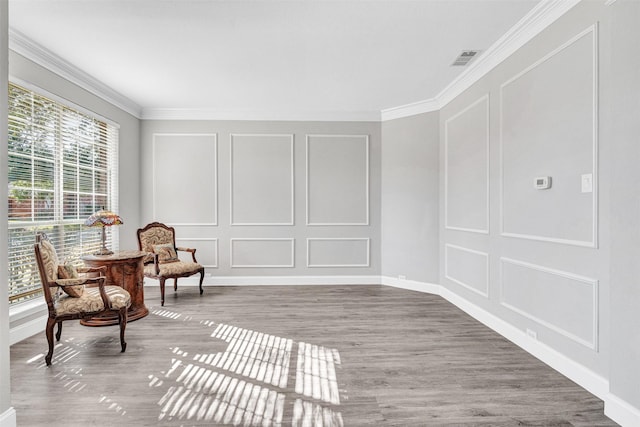 living area with crown molding and hardwood / wood-style floors