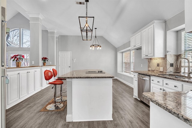 kitchen with a kitchen island, white cabinetry, dishwasher, sink, and dark stone counters