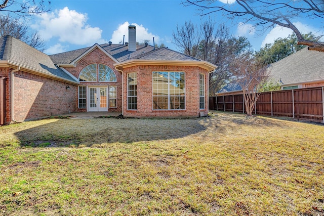 back of house featuring french doors and a lawn