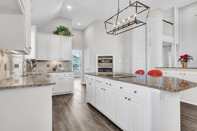 kitchen with white cabinetry, sink, a center island, and stainless steel double oven