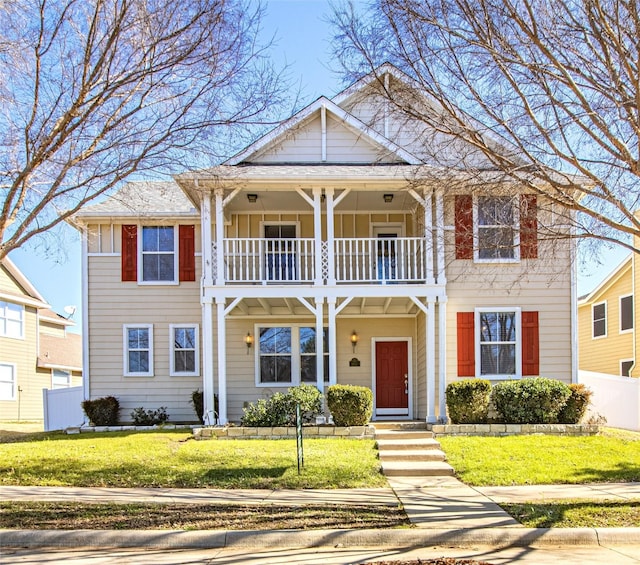 view of front of home with a balcony and a front yard