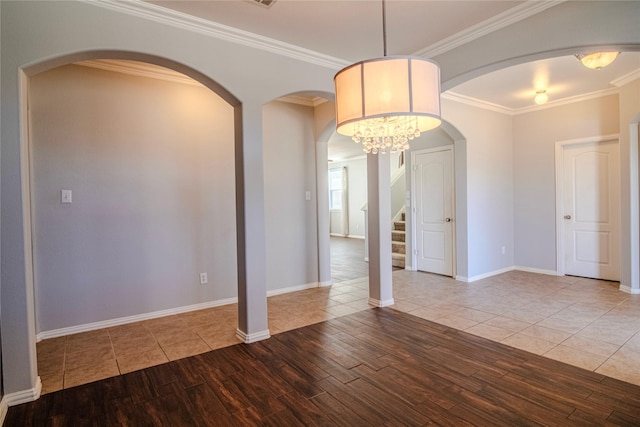 unfurnished room featuring ornamental molding, hardwood / wood-style floors, and a notable chandelier