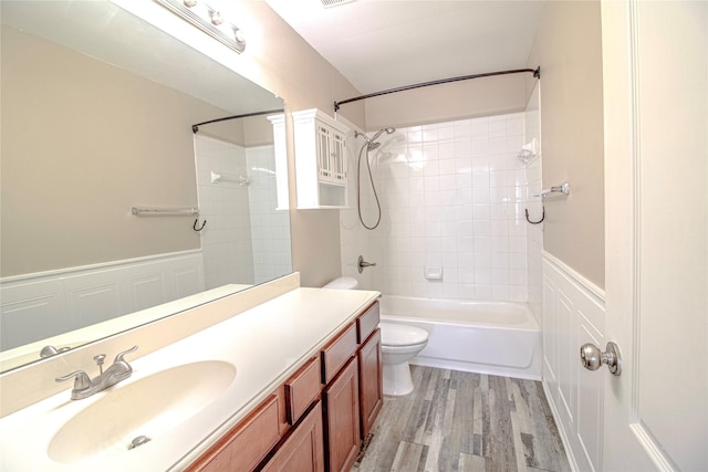 full bathroom featuring tiled shower / bath, wood-type flooring, toilet, and vanity