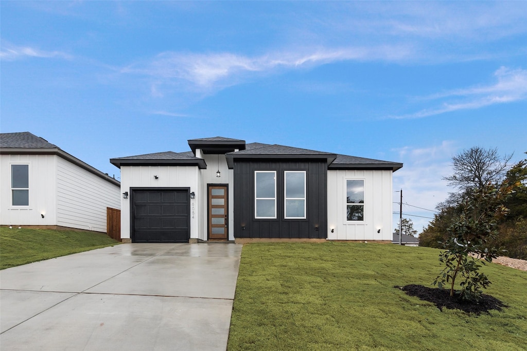 view of front of home with a garage and a front yard