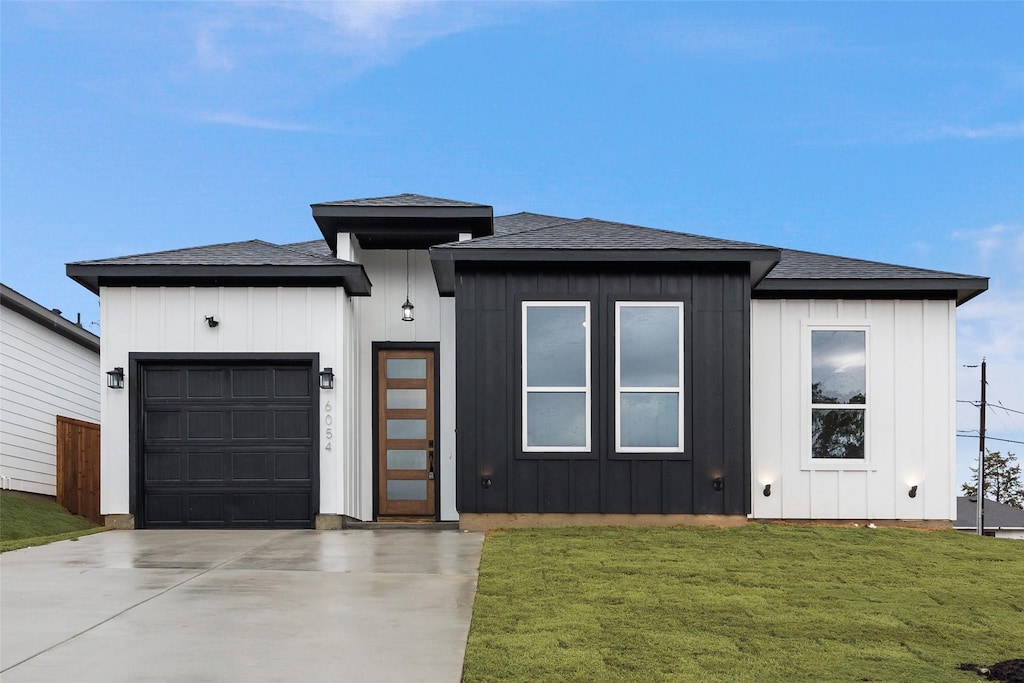 prairie-style house with a garage and a front lawn