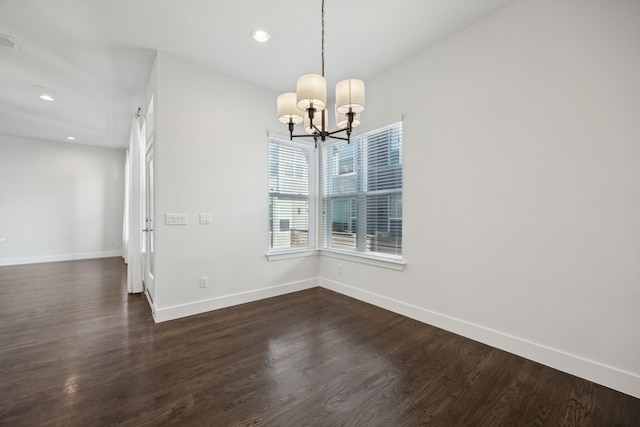 unfurnished dining area featuring dark wood-type flooring and a chandelier