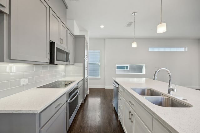 kitchen featuring sink, light stone counters, decorative light fixtures, appliances with stainless steel finishes, and decorative backsplash