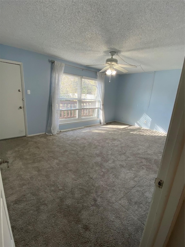 empty room with a textured ceiling, carpet floors, and ceiling fan