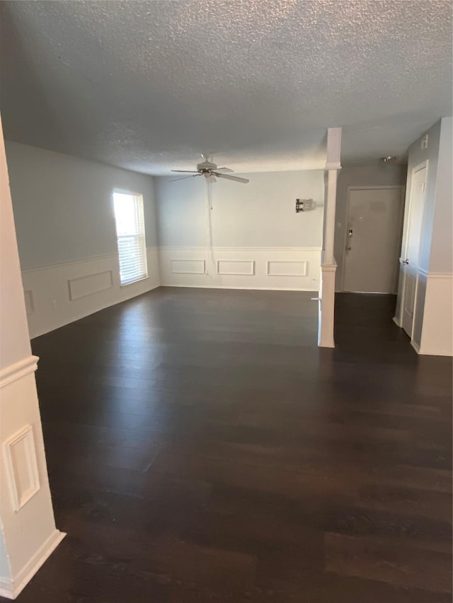 spare room featuring dark wood-type flooring, ceiling fan, and a textured ceiling