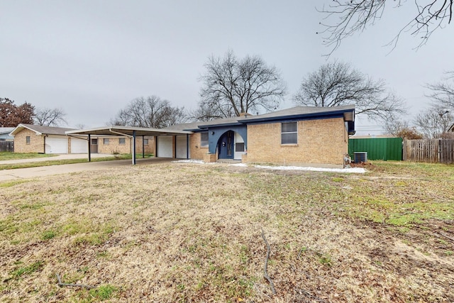 single story home with central AC unit, a garage, a front lawn, and a carport