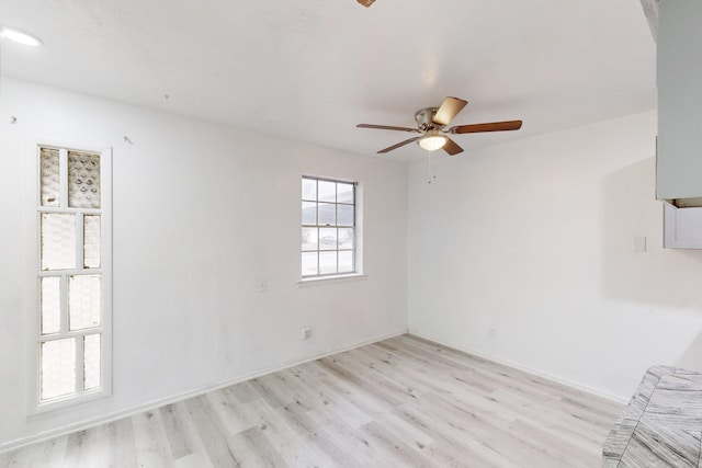 spare room with ceiling fan and light wood-type flooring