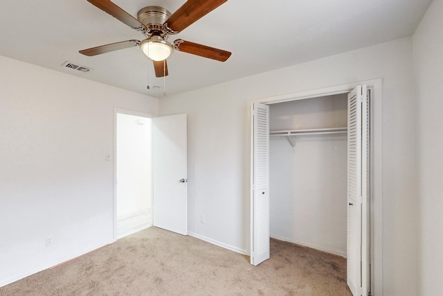 unfurnished bedroom with ceiling fan, light colored carpet, and a closet