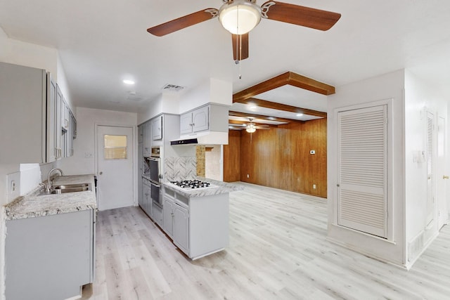 kitchen featuring gray cabinets, white gas stovetop, tasteful backsplash, sink, and light hardwood / wood-style flooring