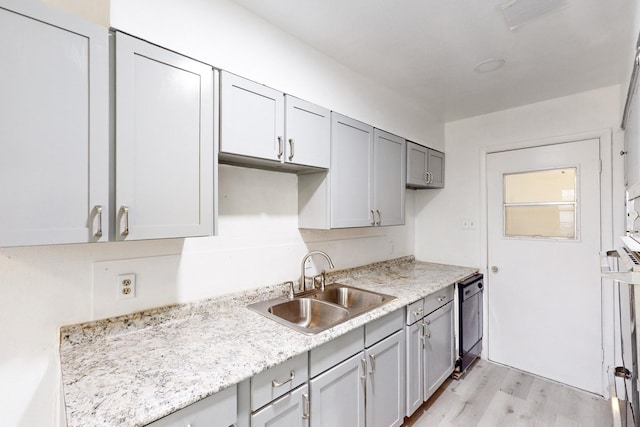 kitchen with gray cabinetry, sink, light hardwood / wood-style flooring, and black dishwasher