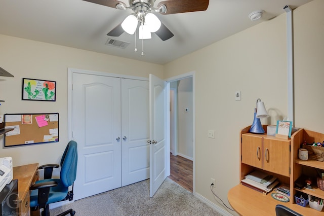 carpeted home office with ceiling fan