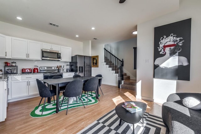 interior space with white cabinetry, stainless steel appliances, light hardwood / wood-style floors, and light stone counters