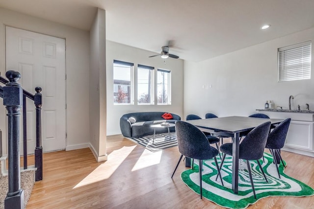 dining space featuring sink, light hardwood / wood-style flooring, and ceiling fan