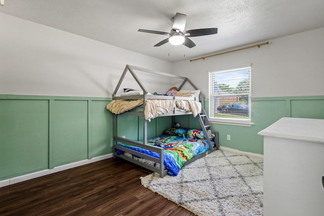 bedroom featuring ceiling fan, dark wood-type flooring, and a textured ceiling