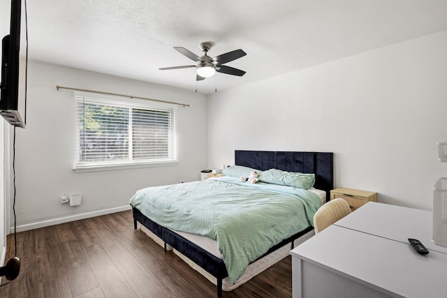 bedroom featuring ceiling fan, dark hardwood / wood-style flooring, and a textured ceiling