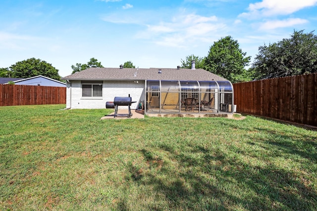 rear view of house featuring a lawn and a patio