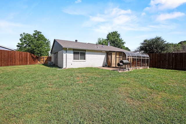 back of house featuring cooling unit, a yard, a sunroom, and a patio